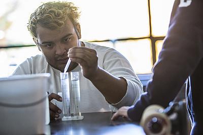 A student uses a dropper to place liquid into a beaker during a science class.  